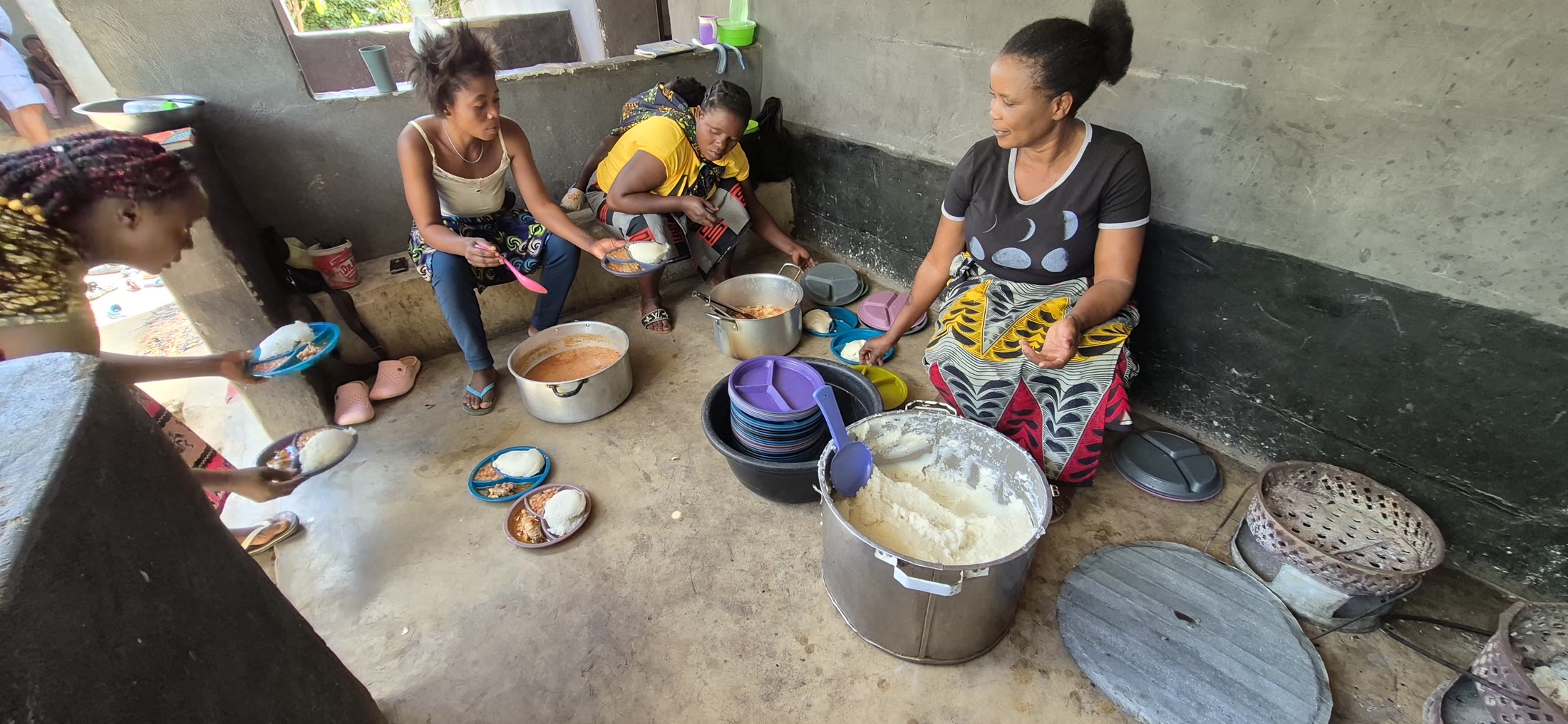 Women preparing and serving hot meals for children